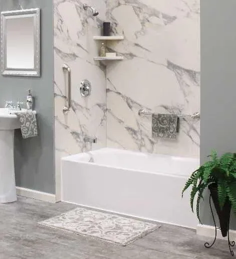 Bathroom renovation showcasing a luxurious marble wall, white fixtures, and a spacious layout.