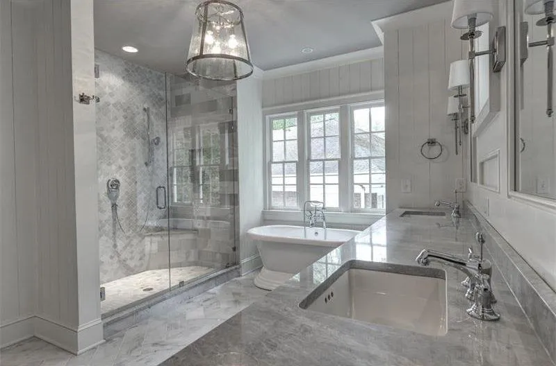 Bathroom renovation showcasing a luxurious design with marble flooring, white walls, and a sleek aesthetic.