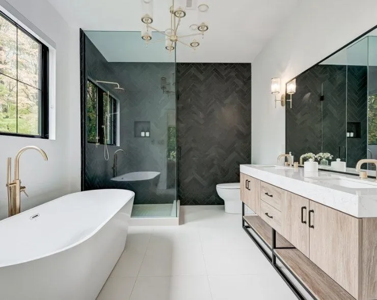 Bathroom renovation showcasing a sleek and stylish space with marble walls, a freestanding tub, and a spacious layout.