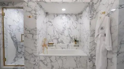Marble bathroom renovation with a spacious shower and dual sinks.