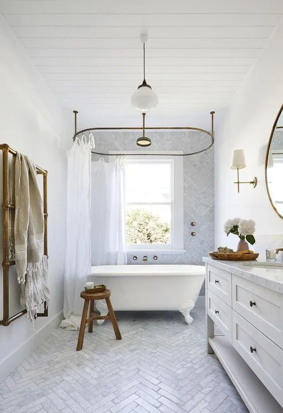 Bathroom with a clean and contemporary design featuring a large tub, a wooden stool, and a white color scheme.
