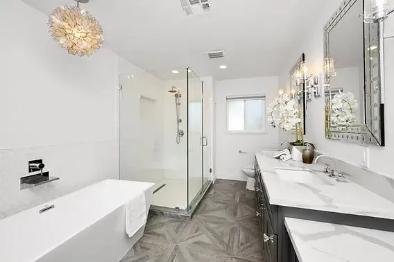 Bathroom renovation featuring a sleek design with white finishes, a large mirror, and a clean, minimalist aesthetic.