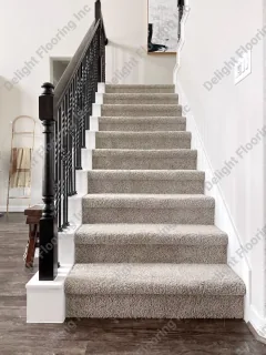 Staircase with carpeted treads and risers, featuring a patterned runner for added texture and safety.