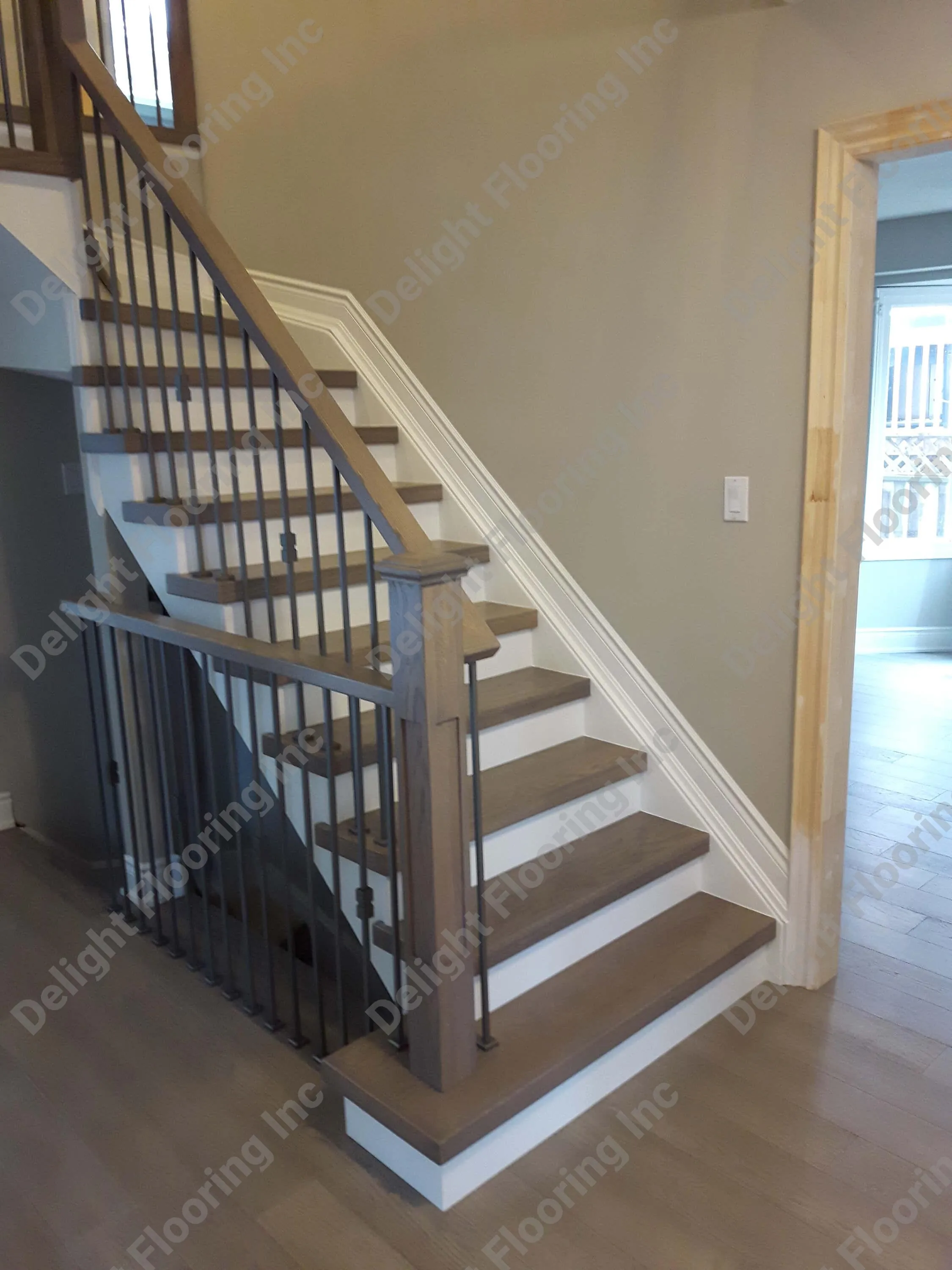 Black railing on hardwood stairs.