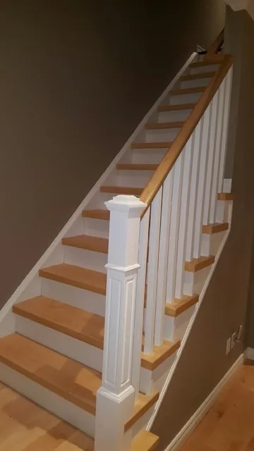 White hardwood stairs with wooden railing.
