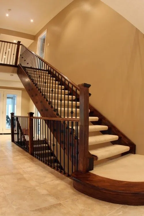 Dark wood staircase with curved nosing and matching runner and railing.