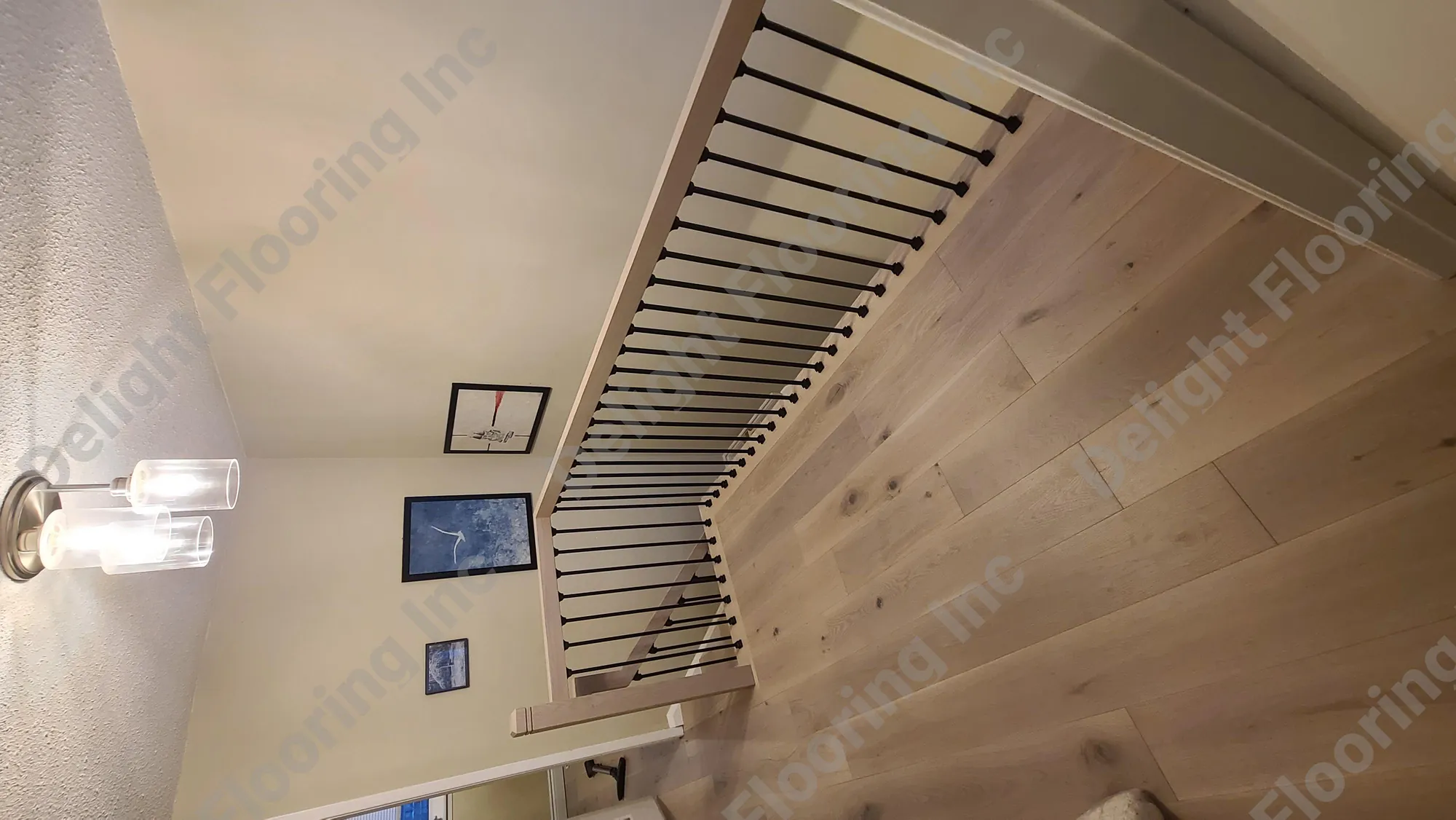 Black metal handrail on wooden staircase railing.