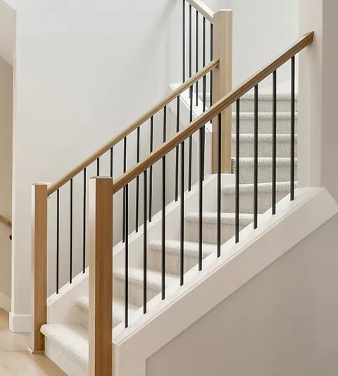 Black metal handrail and balusters on staircase.