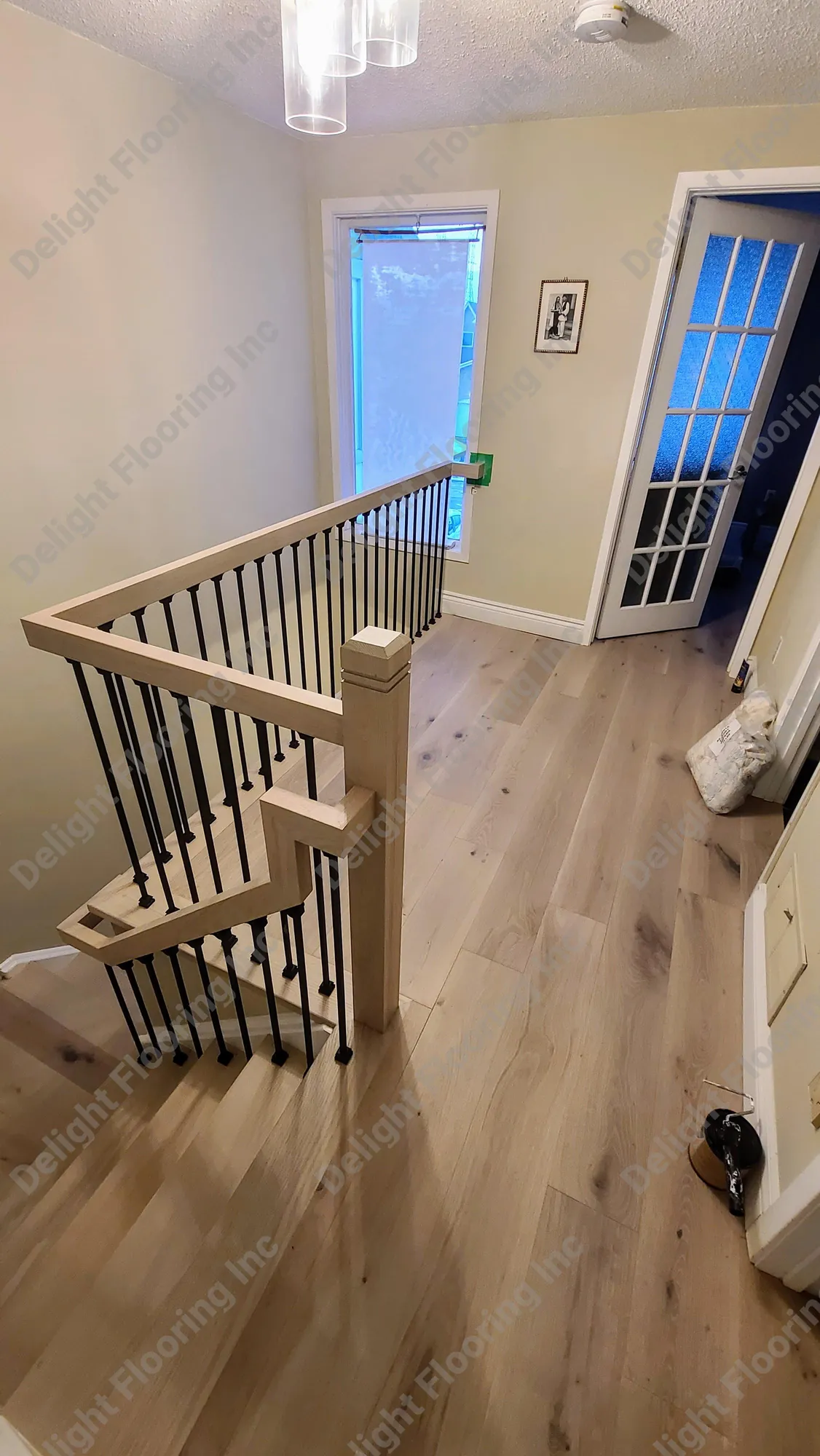 Black metal handrail on wooden staircase railing.