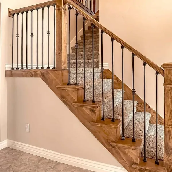 Staircase with wooden railing and black metal handrail.